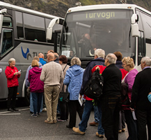 Guide welcoming passengers by the bus at the pier in Flam. By Terje Nesthus.